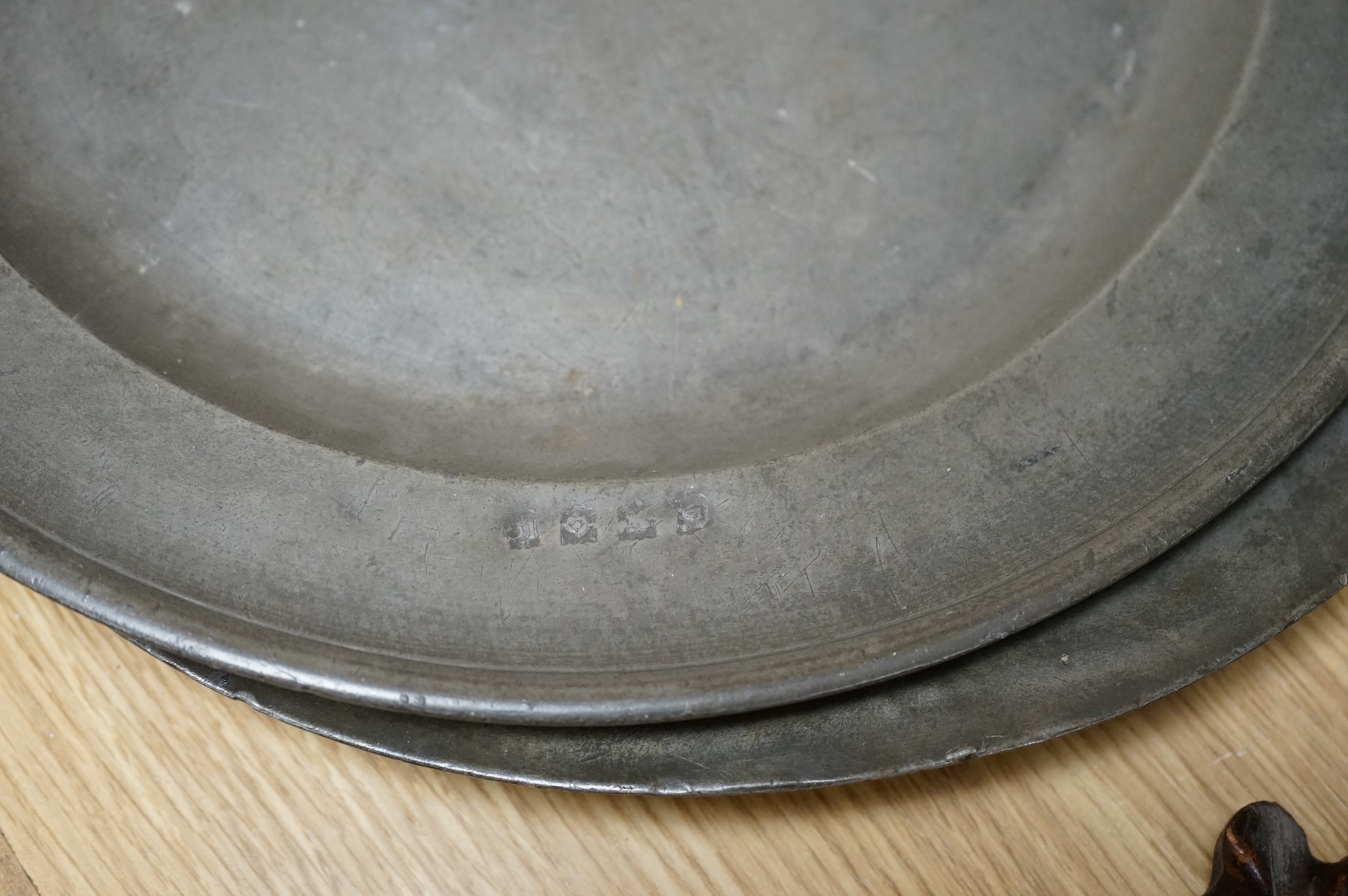Three Pewter chargers, a large dish and a plate, c.1800, largest dish 42cm diameter (5)